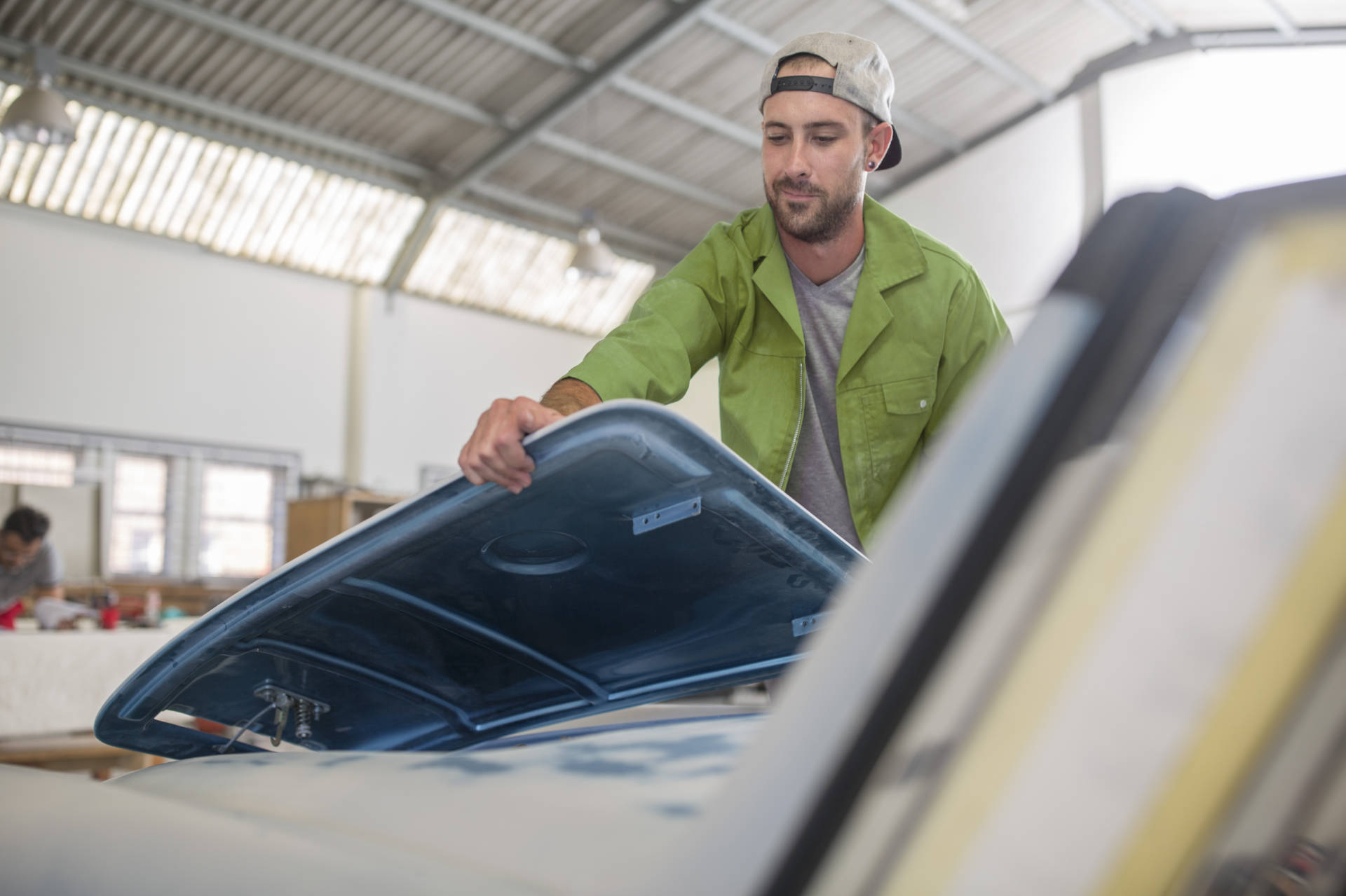 Mann installiert Motorhaube an PKW